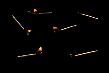 Lit falling match on a black background.
