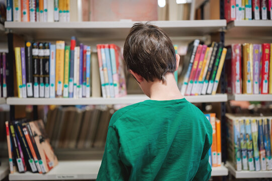 Rear view of a child browsing books in a library
