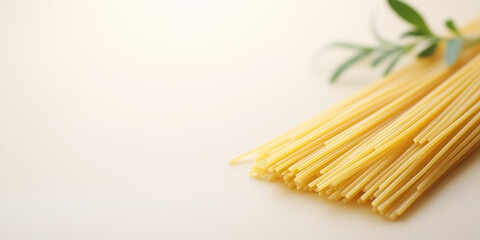 raw spaghetti pasta strands with rosemary sprig on white background with copy space
