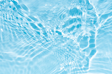 Blue water with ripples on the surface. Defocus blurred transparent blue colored clear calm water surface texture with splashes and bubbles. Water waves with shining pattern texture background.