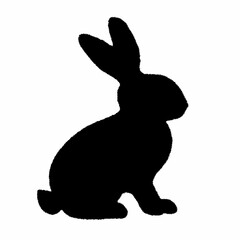 Obraz premium A black rabbit is sitting on the ground. It has a black body and white ears. The rabbit is looking up at the camera