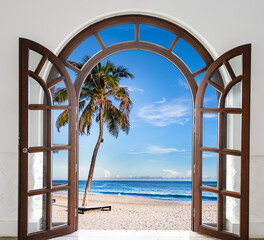 Large open window with a view of the ocean and a palm tree