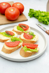 Bruschetta sandwich bread toast with cheese ricotta,tomatoes. healthy vegetarian food,Italian cuisine appetizer,basil greenery on cutting board. top view flat lay.