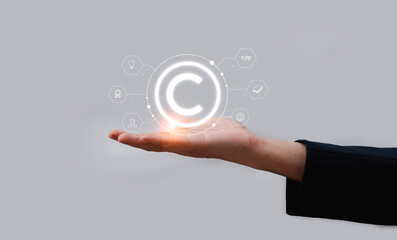 Concept of copyright, patents and intellectual property protection law and rights Intellectual property, symbol of copyright icon in the hand of a businessman
