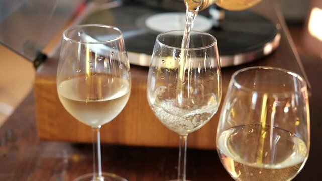  Pour white wine, champagne or prosecco into a glass from a bottle for an aperitif at home, bubbles of French champagne or prosecco in a glass,