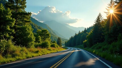 Fototapeta premium Scenic mountain road winding through lush green forest at sunset with sun rays illuminating the landscape