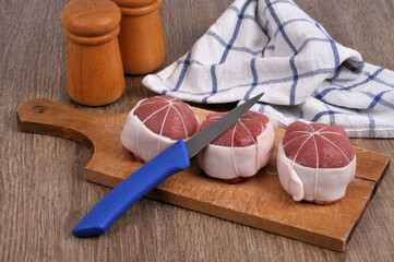 Paupiettes de veau crues sur une planche à découper avec un couteau en gros plan