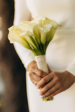 Very beautiful wedding bridal bouquet, made of white roch and austoma, and yellow daisies, green casting of eucalyptus. Wedding, engagement. Bride and groom. Bride's wedding bouquet.