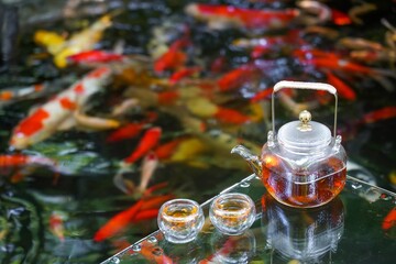 Refreshing afternoon by the summer pond with goldfish, lotus flowers, and a tea set