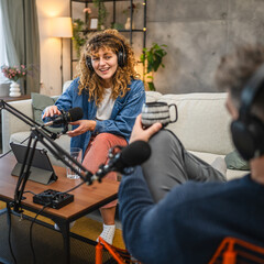 female guests with headphones answer on questions to male presenter