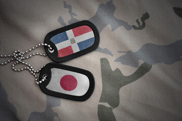 vintage army blank, dog tag with flag of dominican republic and japan on the khaki texture...