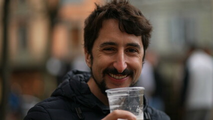 Happy man drinking glass beer smiling and winking to camera