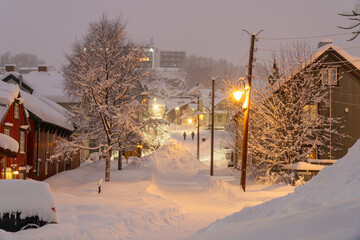 Snowy street of Tromsø, Norway, during the polar night, people walking in the distance