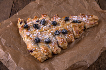 Puff pastry baking in the shape of a Christmas tree with blueberries and cream
