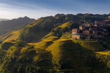 Golden Longji Terraces in Guilin showcase stunning agricultural patterns at sunrise surrounded by lush mountains