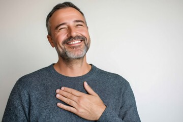 Portrait of a grateful businessman holding his hand over his heart, expressing sincere emotion and appreciation with closed eyes and warm smile