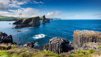 isle of staffa scotland dark hexagonal basalt columns in the turquoise waters of the inner hebrides against a blue summer sky