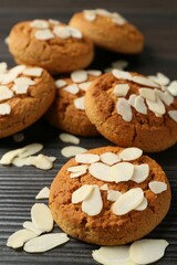 Tasty cookies with almond flakes on wooden table, closeup