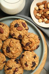 Delicious oatmeal cookies with raisins and nuts on table, top view