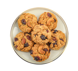Delicious oatmeal cookies with dried cranberries and nuts isolated on white, top view