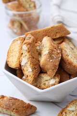Traditional Italian almond biscuits (Cantucci) in bowl on table, closeup