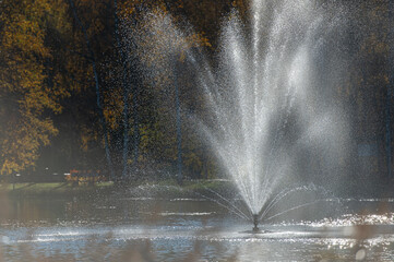 Water fountain in the park illuminated by the evening sun in Vecpiebalga, Latvia