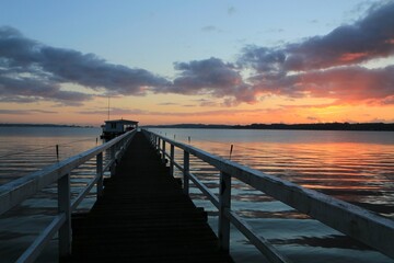Obraz premium Scenic fjord view with boardwalk to a boathouse.