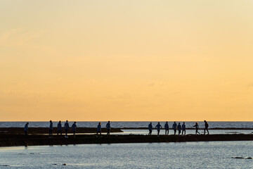 Obraz premium Menschen im Sonnenuntergang am Strand von Rota, Stadt im Südwesten, Spanien, Andalusien in der Provinz Cádiz / Costa de la Luz
