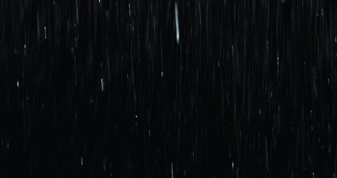 4K high-speed angled heavy rainstorm on a black surface, dynamic splashing of raindrops. High-end rain closeup VFX insert, a powerful weather element, showcasing the intense realism of the rain.	