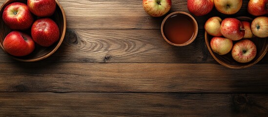 Red apples in wooden bowls on a rustic table with apple juice in a small cup and ample copy space for text insertion