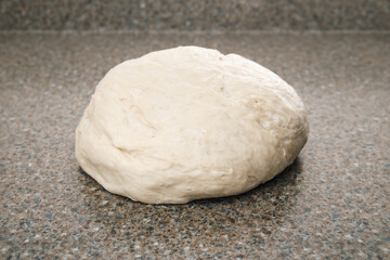 Bread dough on kitchen counter. Raw kneaded yeast bread resting on table. Ready for first rise. Traditional Swiss butter bread recipe called Zopf or Butterzopf. Or challah bread. Selective focus.