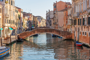Picturesque Venetian Canal with Stone Bridge and Boats