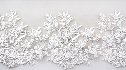 Intricate white floral lace trim with detailed embroidery on a light background showing copy space for design applications