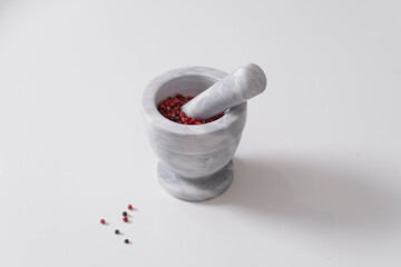 Pink peppercorns in a marble mortar