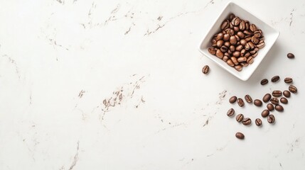Coffee beans in a white bowl with scattered beans on a marble background featuring ample copy space for text placement.