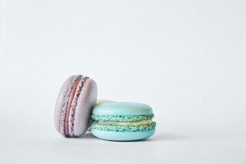 Stack of two colorful French Macarons, cakes with different flavors, mint, apple, currant flavor. pyramid of homemade dessert, macaroons aquamarine, green, purple color. Copy space for text