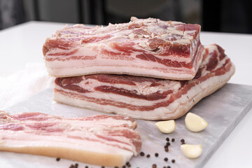 Homemade lard piece on marble light board on white table