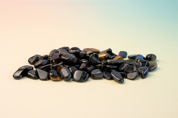 macro shooting of natural mineral stone - tumbled hawks eye gemstone isolated on light background