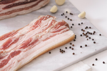 Homemade lard piece on marble light board on white table