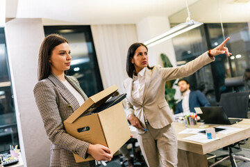 Businesswoman got fired from her job. Taking box with her personal stuff from the office.