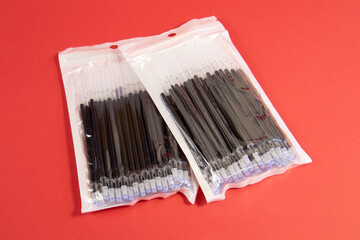 Ballpoint pens and ink refills on red background stationery