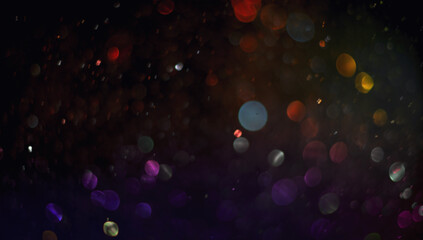 Holiday abstract bokeh on black background. Festive sparkling gold dust. Holiday concept