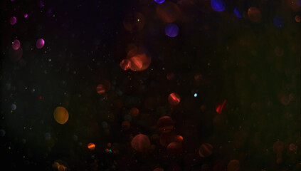 Holiday abstract bokeh on black background. Festive sparkling gold dust. Holiday concept