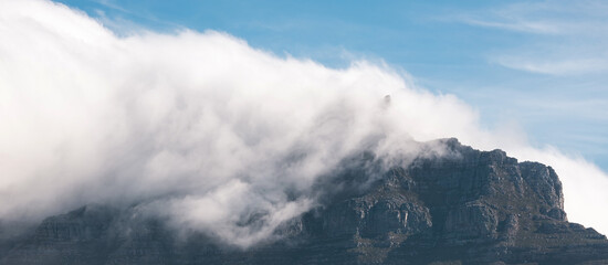 Tafelberg, close-up Table Mountain in big cloud, shrouded in fog, Cape Town, South Africa. Banner, natural landscape, blue sky