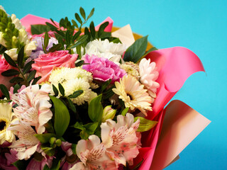bouquet of flowers close up . pink roses, purple and white carnations, lilies . wedding bouquet on blue background . mother's day . many flowers