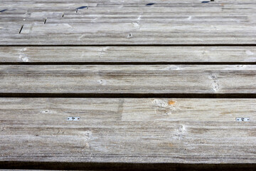 
Close-up of worn wooden planks joined together to form a surface with visible gaps between the...