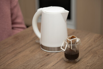 Delicate hand-crafted drip coffee preparation using a sleek kettle in a cozy setting