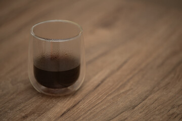 Drip coffee served in a glass cup on a wooden table in a cozy setting