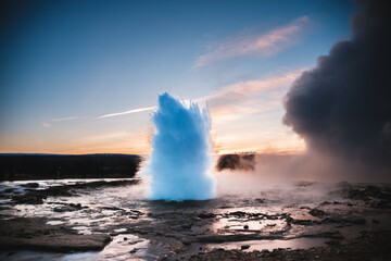 Strokkur Geysir eruption at sunset in south Iceland, Haukadalur valley