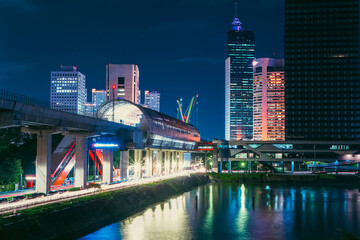 Jakarta vibrant cityscape at night, illuminated by a myriad of lights. A modern elevated train track traverses the scene, adding a dynamic element to the composition.